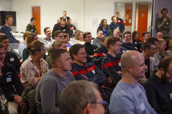 Groep collega's die lachen naar een kant van de zaal