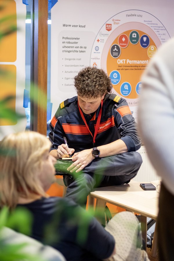 Brandweerman met krullend haar schrijft dingen op