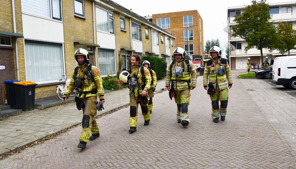 Brandweermensen in bluspak lopen over straat