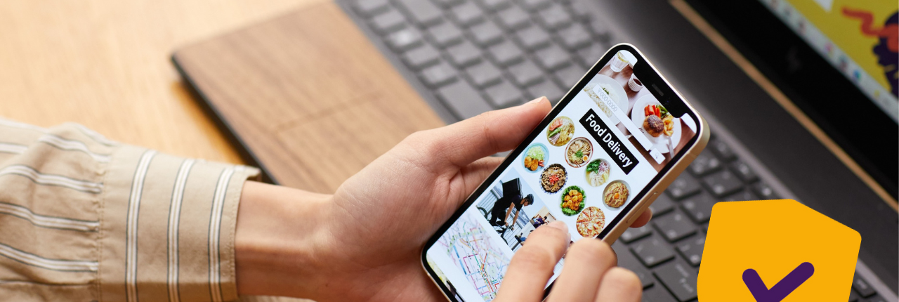 Iemand met een laptop en mobiel in hand