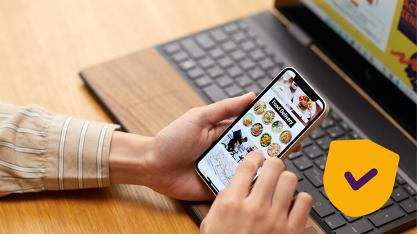 Iemand met een laptop en mobiel in hand