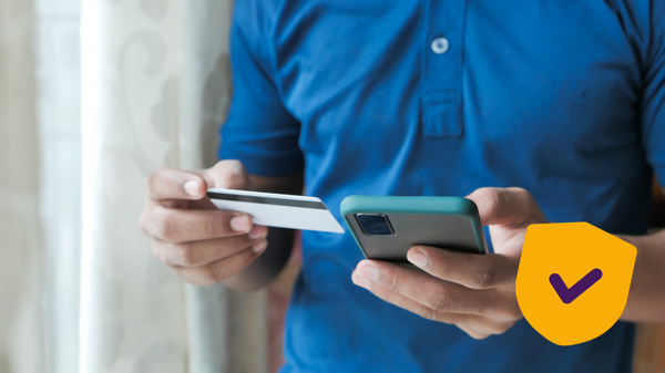 Persoon heeft mobiel en bankpas in z'n hand