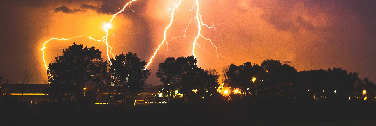 Grote blikseminslag bij een rij bomen