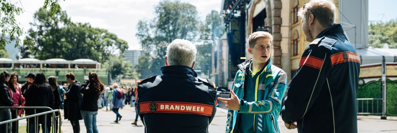 foto van drie mannen in uniform die in gesprek zijn tijdens een evenement