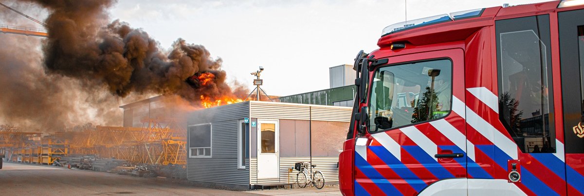 Brandweervoertuig voor brandend gebouw