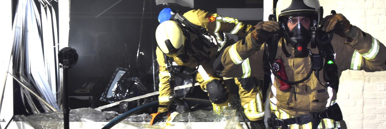 brandweermensen aan het werk bij een incident in een gebouw