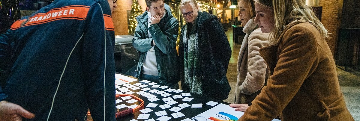 Groep rondom tafel bij een brandweerman