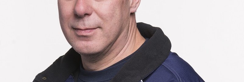 Brandweerman geposeerd voor een witte muur