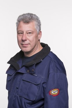 Brandweerman geposeerd voor een witte muur