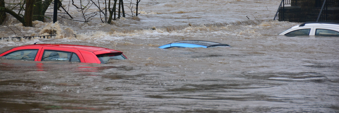 Auto's onder water door een overstroming midden in een dorp