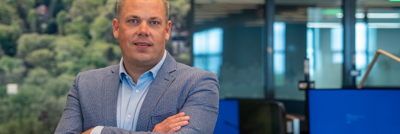 Portret van Nick van Schaick in de meldkamer Midden Nederland. Achter Nick zijn werkplaatsen zichtbaar.