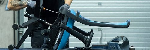 Monteur repareert de zitting van een bureaustoel