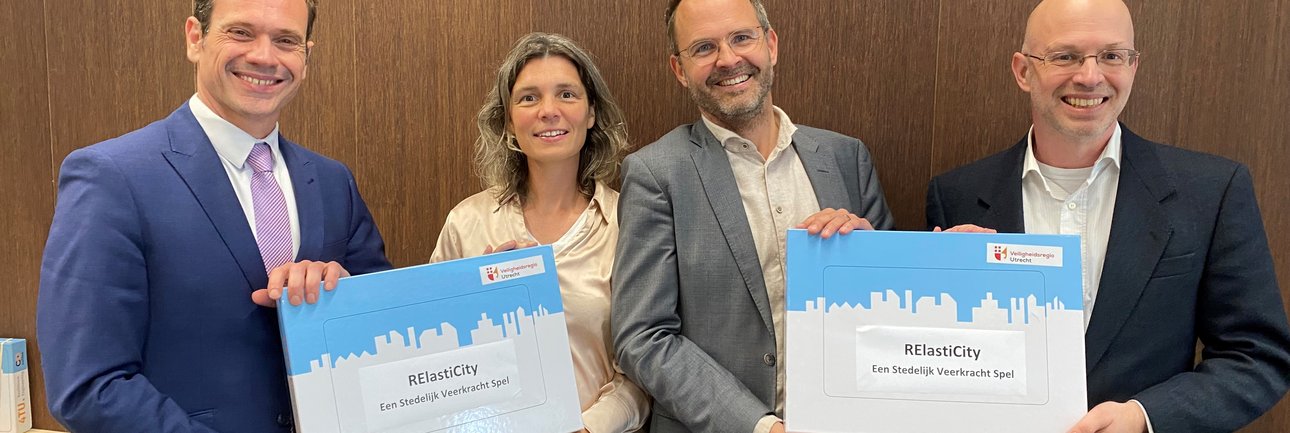 Drie mannen en één vrouw die lachen in camera