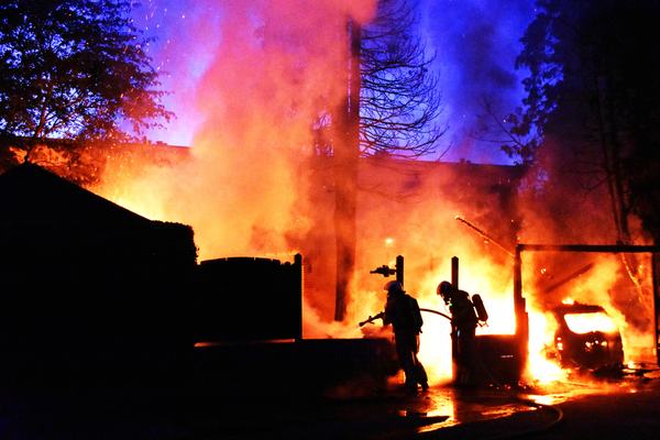 Brand in een gebouw in de avond, met vlammen zichtbaar