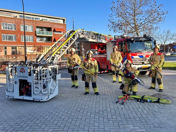 Brandweermensen naast het voertuig