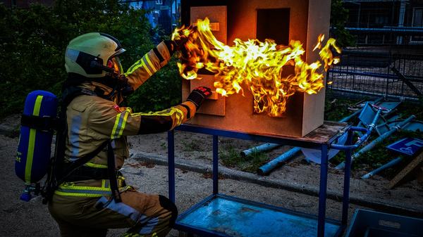 Afbeelding van brandweerman die demonstratie met vuur geeft op open dag.