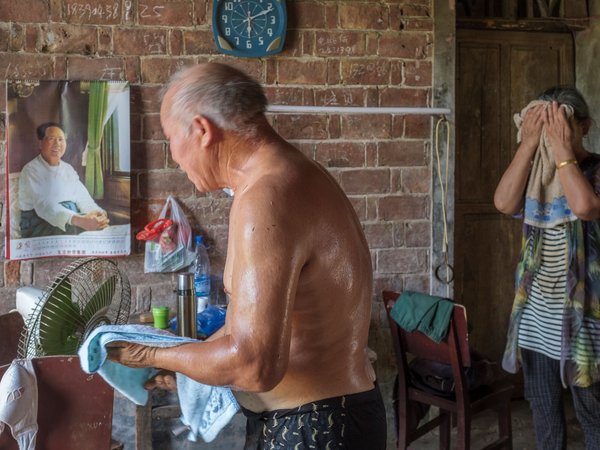 "Twee mensen die het warm hebben en hun bezweette gezichten afvegen met een handdoek"