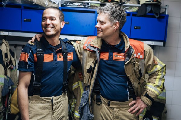 Twee brandweermannen die elkaar omarmen